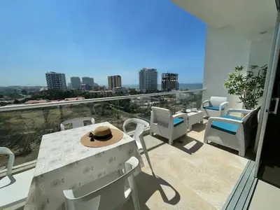 a balcony with a table and chairs and a view of the city at Apartamento Bello Horizonte Santamarta in Santa Marta