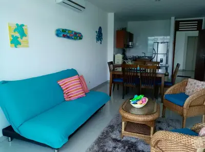a living room with a blue couch and a table at Apartamento Frente al Mar in Santa Marta