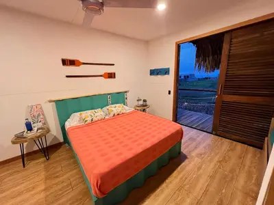 a bedroom with a bed and a sliding glass door at KITE en Mojarra Beach Habitación privada vista al mar in Salina de Rey