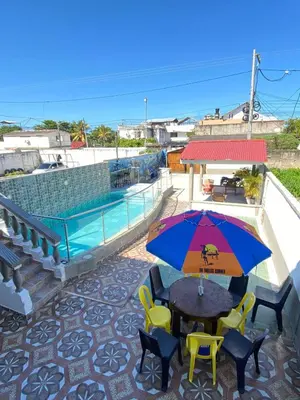 a patio with a table and chairs and an umbrella at Cabaña Tolu Sucre in Santiago