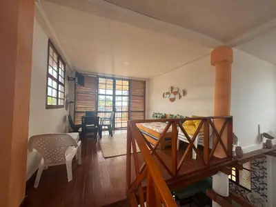 a room with a staircase and a living room with a table at Cabaña frente al mar de San Antero in San Antero