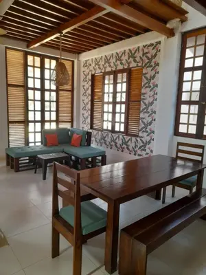 a living room with a wooden table and benches at Cabaña frente al mar de San Antero in San Antero