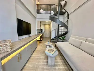 a living room with a couch and a spiral staircase at Luxury Loft in the Historic Center - Rooftop Pool in Cartagena de Indias