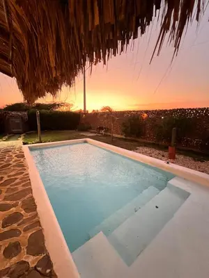a swimming pool with a sunset in the background at Love en Mojarra Beach Habitación privada vista al mar in Salina de Rey