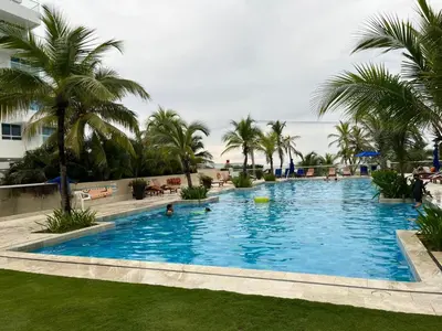 a large pool with palm trees and people in it at Hermoso apartamento MORROS EPIC in Cartagena de Indias