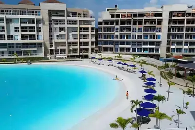 a large pool with chairs and umbrellas and buildings at Baia Kristal 5I in Estación El Salto