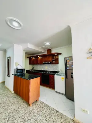 a large kitchen with a counter and a refrigerator at Loft Vista al Laguito in Cartagena de Indias