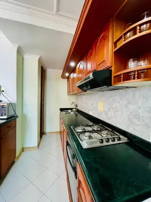 a kitchen with wooden cabinets and a stove top oven at Loft Vista al Laguito in Cartagena de Indias