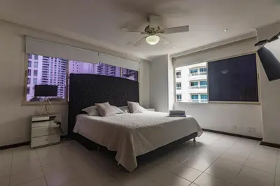 a bedroom with a large bed and two windows at Apartamento frente al mar in Cartagena de Indias