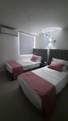 a hotel room with two beds with red pillows at Apartamento completo con vista a la ciudad in Cartagena de Indias