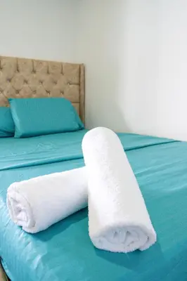 a roll of white towels on a bed at Hostal barú in Bolivar