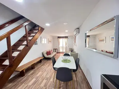 a living room with a table and chairs and a staircase at Hermoso duplex en la ciudad amurallada! A218 in Cartagena de Indias
