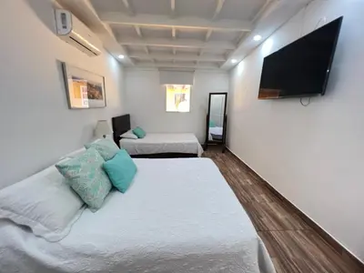 a room with two beds and a flat screen tv at Hermoso duplex en la ciudad amurallada! A218 in Cartagena de Indias
