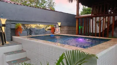 a swimming pool in a backyard with a brick wall at cabaña villa luz in Santa Veronica