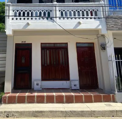 two red doors on a white building with a balcony at Casa lo amador alojamiento entero in Cartagena de Indias