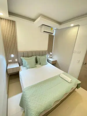 a bedroom with a large white bed with green pillows at Terrazas Vista al Mar y Piscina Espectacular in Cartagena de Indias
