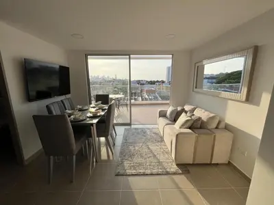 a living room with a table and a couch and a dining room at Apartamento con balcón grande in Cartagena de Indias