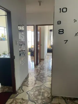 a hallway with a clock on the wall in a house at comodo apartamento in Barranquilla