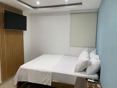 a bedroom with a bed with a tv on the wall at Hotel Boulevard 58 in Galapa