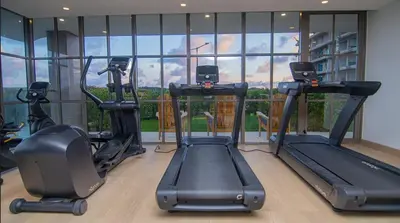 a gym with three tread machines in front of a window at Exclusive Apartment With Ocean View By Huespedia in Cartagena de Indias