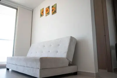 a white couch sitting in a room with a window at Apartamento cerca al aeropuerto in Cartagena de Indias