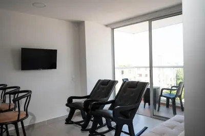 a living room with chairs and a flat screen tv at Apartamento cerca al aeropuerto in Cartagena de Indias