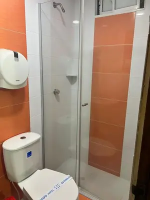 a bathroom with a toilet and a glass shower at Hotel Don Fermin in Barranquilla