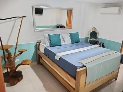 a bedroom with a bed with blue sheets and a mirror at Hotel Boutique Tierra Del Mar Cartagena in Cartagena de Indias