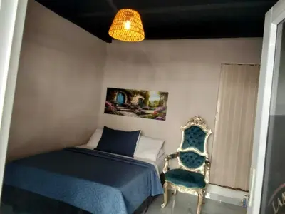 a bedroom with a bed and a chair at Hotel Boutique Tierra Del Mar Cartagena in Cartagena de Indias