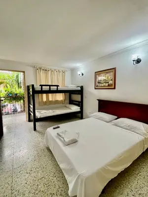 a bedroom with a bed and a bunk bed at Hotel Casa Fátima in Cartagena de Indias