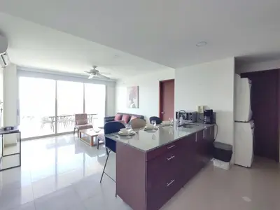 a kitchen and living room with a counter and a refrigerator at Hermoso Apto playa de Morros! in Cartagena de Indias