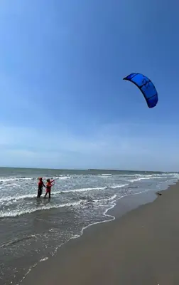 two people standing in the ocean flying a kite at La Boquilla Kite House in Cartagena de Indias