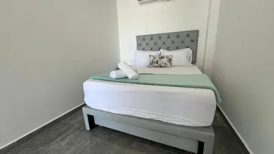 a bedroom with a large bed with white sheets and pillows at La Boquilla Kite House in Cartagena de Indias