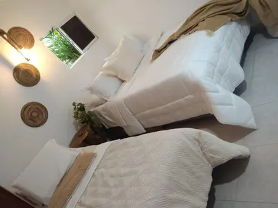a bedroom with two beds with white sheets and a window at Cartagena Hotel Boutique - Manga - Tierra del Mar - Colombia in Cartagena de Indias