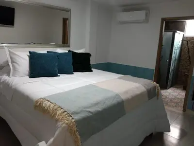 a bedroom with a large white bed with blue pillows at Cartagena Hotel Boutique - Manga - Tierra del Mar - Colombia in Cartagena de Indias