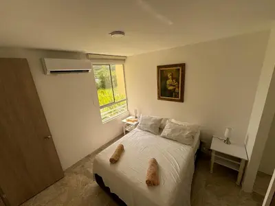 a bedroom with a bed and a desk and a window at Apartamento de una habitación en serena del mar en cartagena DAMMAR in Manzanillo del Mar