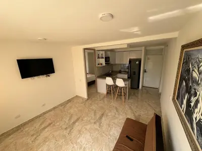 a living room with a couch and a television on a wall at Apartamento de una habitación en serena del mar en cartagena DAMMAR in Manzanillo del Mar