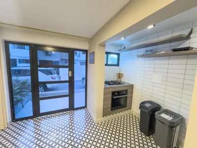 a kitchen with two trash cans next to a door at Casa Martina Manga Cartagena in Cartagena de Indias