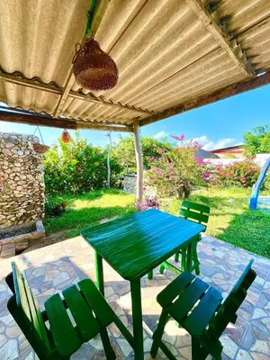 a green table and chairs on a patio at Hermosa Cabaña privada cerca a la Playa in Puerto Colombia