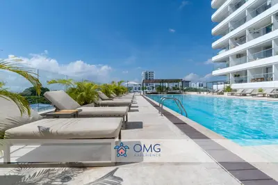 a row of chaise lounge chairs next to a swimming pool at Acogedora Suite Frente al Mar - Aeropuerto CB617 in Cartagena de Indias