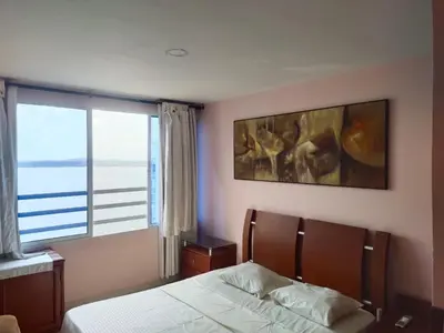 a bedroom with a bed and a large window at Bahia del caribe Apartment in Cartagena de Indias