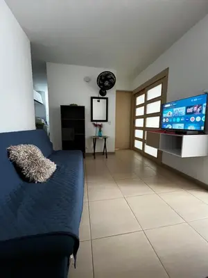 a living room with a couch and a flat screen tv at Alessandro estilo italiano in Cartagena de Indias