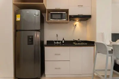 a kitchen with a stainless steel refrigerator and white cabinets at Suite Cama King Balcon Vista Hermosa CB634 in Cartagena de Indias