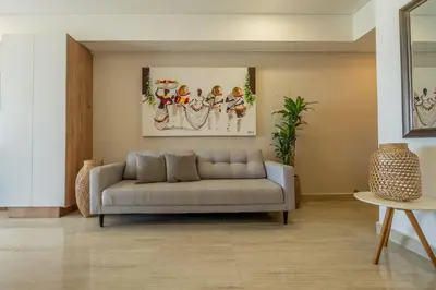 a living room with a couch and paintings on the wall at CB802 | Escapada frente al mar en Cartagena in Cartagena de Indias