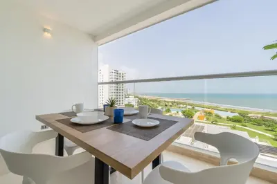 a dining room with a table and chairs and a large window at CB802 | Escapada frente al mar en Cartagena in Cartagena de Indias