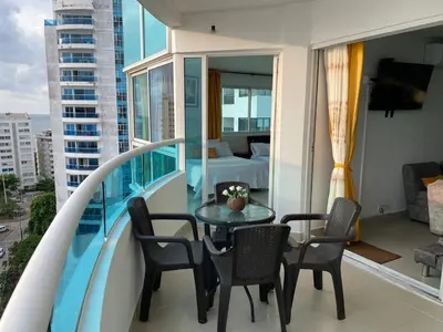 a balcony with a table and chairs and a bedroom at Tropical Paradise - vista al mar, el Laguito Cartagena in Cartagena de Indias