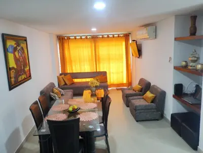 a living room with a table and a couch at Tropical Paradise - vista al mar, el Laguito Cartagena in Cartagena de Indias