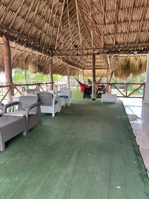 a straw roofed pavilion with chairs and a table at Hotel Restaurante Arrecife in Isla de Tierra Bomba