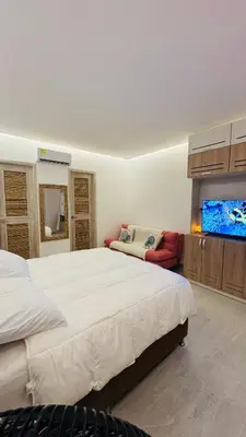 a bedroom with a large bed and a flat screen tv at Eco Hotel Laguna Beach - Bloque 8 Suite 101 in San Silvestre