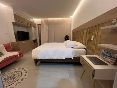 a bedroom with a large white bed and a tv at Eco Hotel Laguna Beach - Bloque 8 Suite 101 in San Silvestre